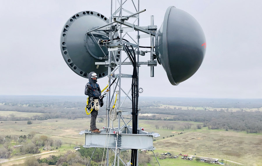 image of man on top of utilities tower